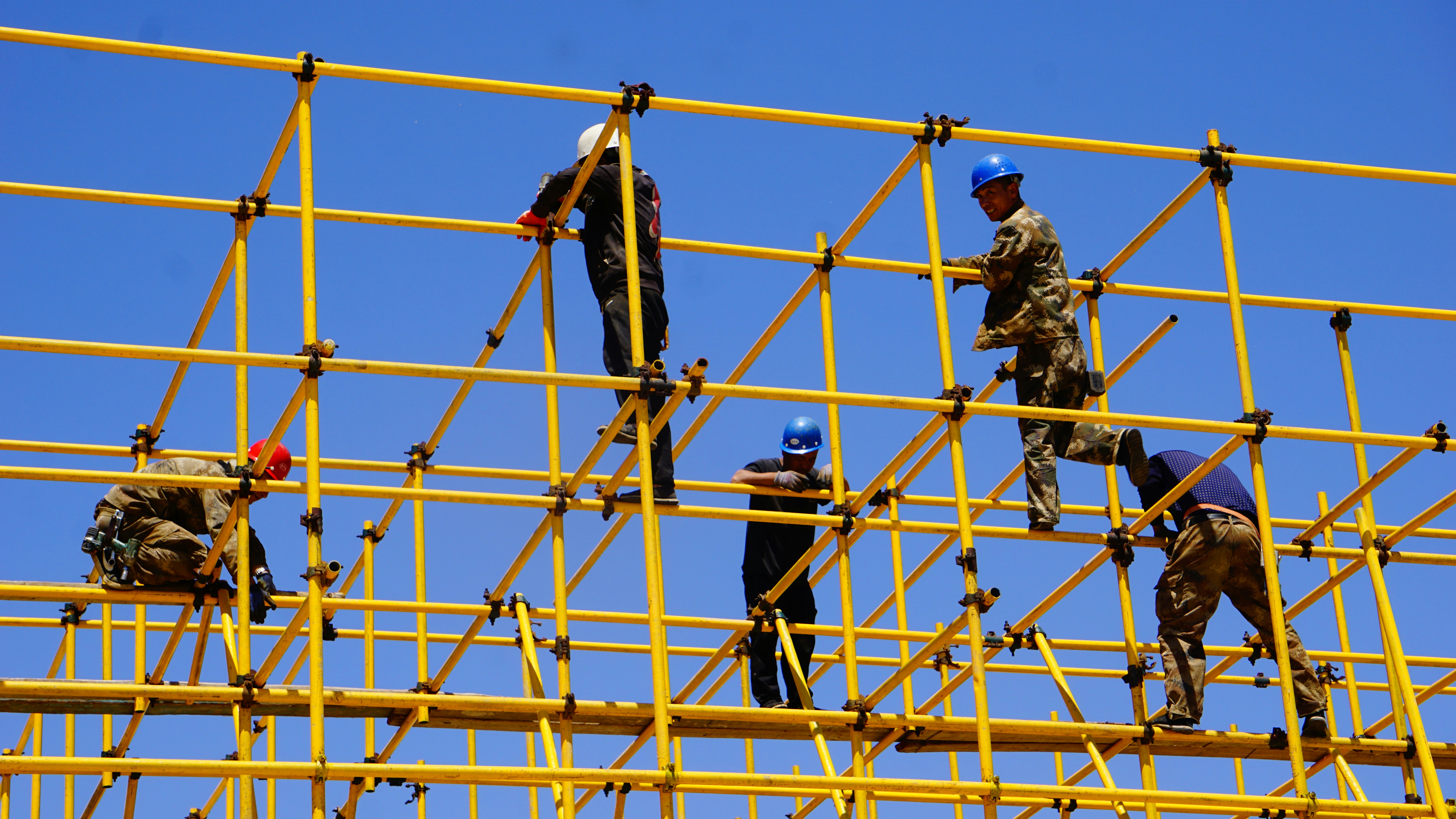 Five men working on a construction site precisely